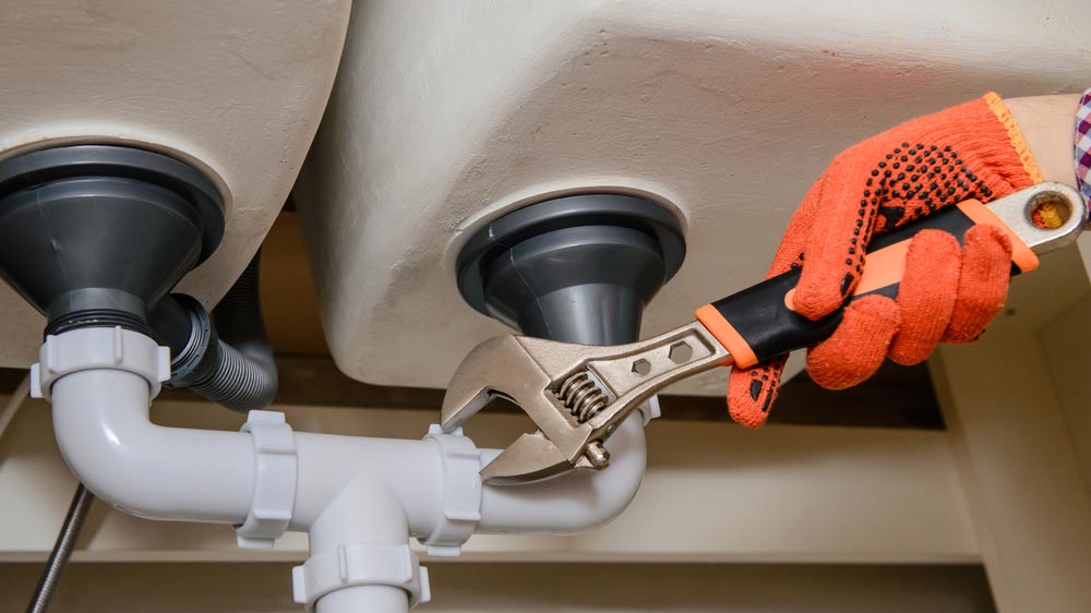 Plumber fixing pipe under sink Harrisonburg, VA