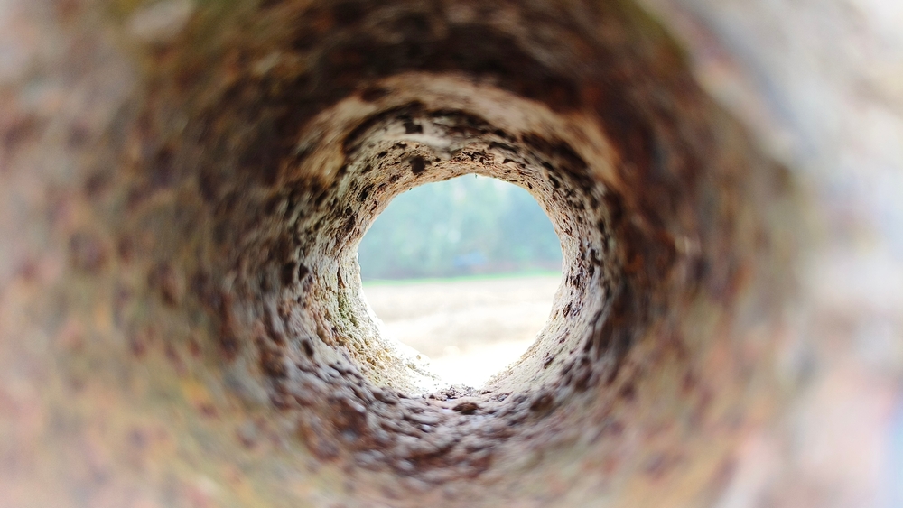 Old iron metal dirty sewer or drainage round pipe hole inside view with rust